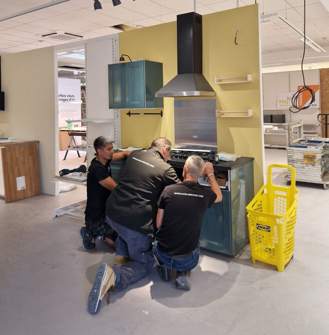 Équipe ALTEA installant une cuisine d'exposition